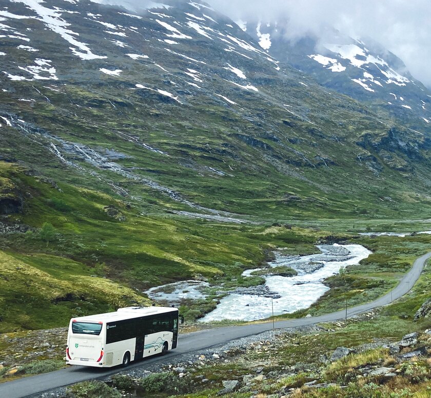 Buss som kjører i fjellandskap innover Leirdalen - Klikk for stort bilde