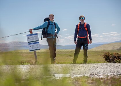 To menn står og venter på bussen. - Klikk for stort bilde